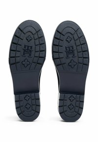 Suole di gomma navy con un motivo di grip texturizzato. Logo in evidenza e accenti decorativi, progettati per resistenza e trazione.