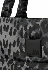 Sort og grå leopardprint tote bag lavet af glat nylon med to robuste håndtag og et tekstureret sort mærkepatch.