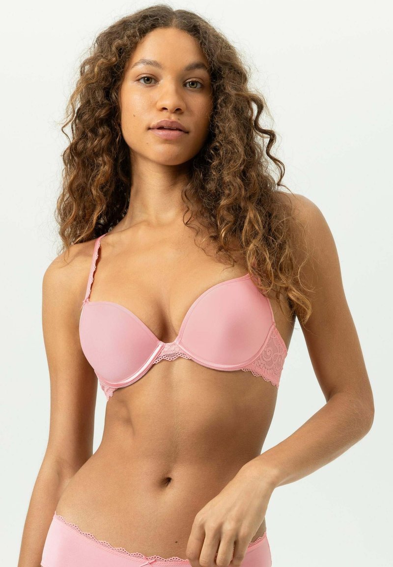 Hellrosa gepolsterter Büstenhalter mit Spitzenakzenten, geformten Körbchen, verstellbaren Trägern und einer glatten Textur auf der Haut. Passender Slip gezeigt.