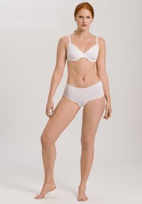 White bra with thin straps and smooth cups, paired with high-waisted white briefs. Both garments have a seamless design and a soft texture.
