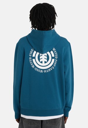 Niebieska bluza z kapturem i ściągaczami przy rękawach. Na plecach znajduje się duża biała okrągła grafika oraz napis. Wykonana z miękkiego materiału, mieszanki bawełny.
