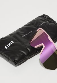 Occhiali sportivi con montatura rosa, lenti sfumate da viola a verde, esposti sopra una custodia nera imbottita con marchio in testo bianco.