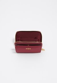 Cartera de cuero burdeos con herrajes dorados, cierre de cremallera y múltiples compartimentos para tarjetas en el interior. Textura suave con un diseño minimalista.