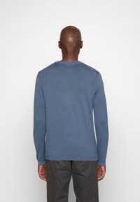 Maglione blu a maniche lunghe con colletto rotondo e polsini a coste. Tessuto a maglia morbido con una superficie liscia. Nessun motivo o accento visibile.