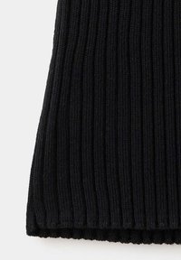 Gros plan sur un tissu tricoté côtelé noir avec des lignes verticales texturées et un bord légèrement cranté en bas.