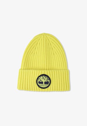 Geel gebreide beanie met ribbelstructuur, voorzien van een zwarte ronde patch met een boomlogo. Klassiek slouchontwerp, zacht materiaal.