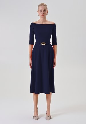 Navy Off-Shoulder Kleid mit Dreiviertelärmeln und taillierter Passform, mit einem goldenen Schnallen-Gürtel. Elegante A-Linie und glattes Material.