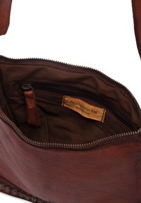 Smeđa kožna torba za rame sa zatvaračem, s tekstilnom unutrašnjošću, bočnom unutrašnjom džepom i oznakom koja ukazuje da je ručno izrađena.