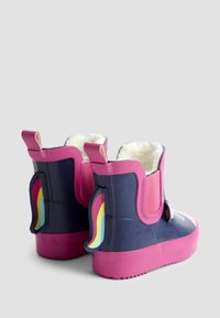 Stivali in gomma con una parte superiore blu navy, suola rosa e fodera morbida. Accenti arcobaleno sul retro e pratiche linguette per facilitarne l'indossamento.