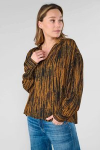 Langsleeve, V-hals top in zwart en bruin met een textuur van abstracte patronen. Zachte stof met een losse pasvorm, gecombineerd met blauwe spijkerbroeken.