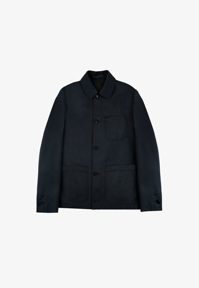 Donkerblauwe jas van een gladde stof, met een kraaghalslijn, vier zakken, knoopsluiting en textuuraccenten.