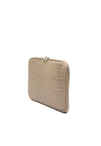 Beige laptopsleeve med krokodillemønster, tekstureret overflade, glat lynlås i lukningen, rektangulær form og afrundede kanter.