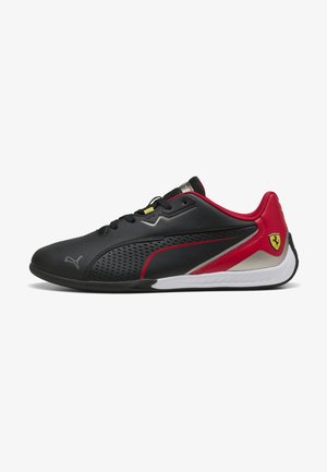 Zapatilla negra y roja con un upper texturizado, diseño perforado, detalles en plata y una suela blanca. Presenta el logo de Puma y el emblema de Ferrari.