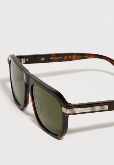 Lunettes de soleil rectangulaires en écaille de tortue avec verres vert foncé et détails argentés rayés gravés de "Ferragamo" sur les branches.