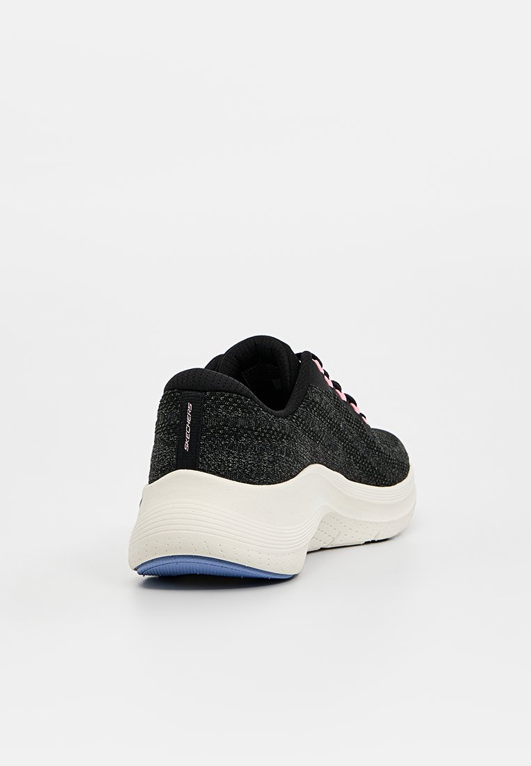 Zapatilla deportiva negra con parte superior de punto texturizado, con una mediasuela blanca y suela azul, realzada por cordones rosas.