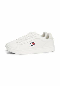 Weiße synthetische Sneakers mit glatter Textur, die ein Logo in Rot und Blau zeigen. Sie haben eine abgerundete Zehenpartie und ein Schnürdesign.