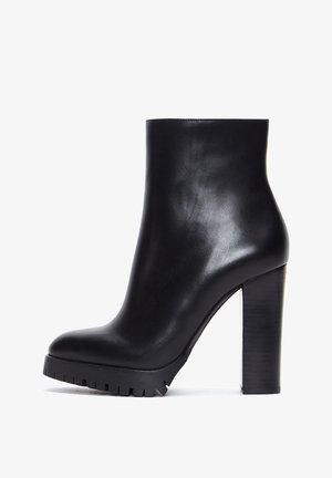 Sorte læderankelstøvler med chunky hæl og tekstureret sål. Glat finish og slank silhuet med rundet tådesign.