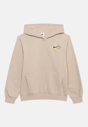 Smėlinis Nike džemperis su kišene priekyje, ant krūtinės geltonos ir juodos spalvų globuso grafika su Nike logotipu viduje, gobtuvu be raištelių.