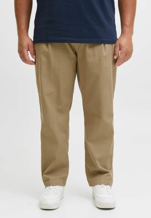 Beige Chinos aus Baumwollmischung, mit entspanntem Schnitt, vorderen Falten und geraden Beinen, kombiniert mit weißen Sneakers.
