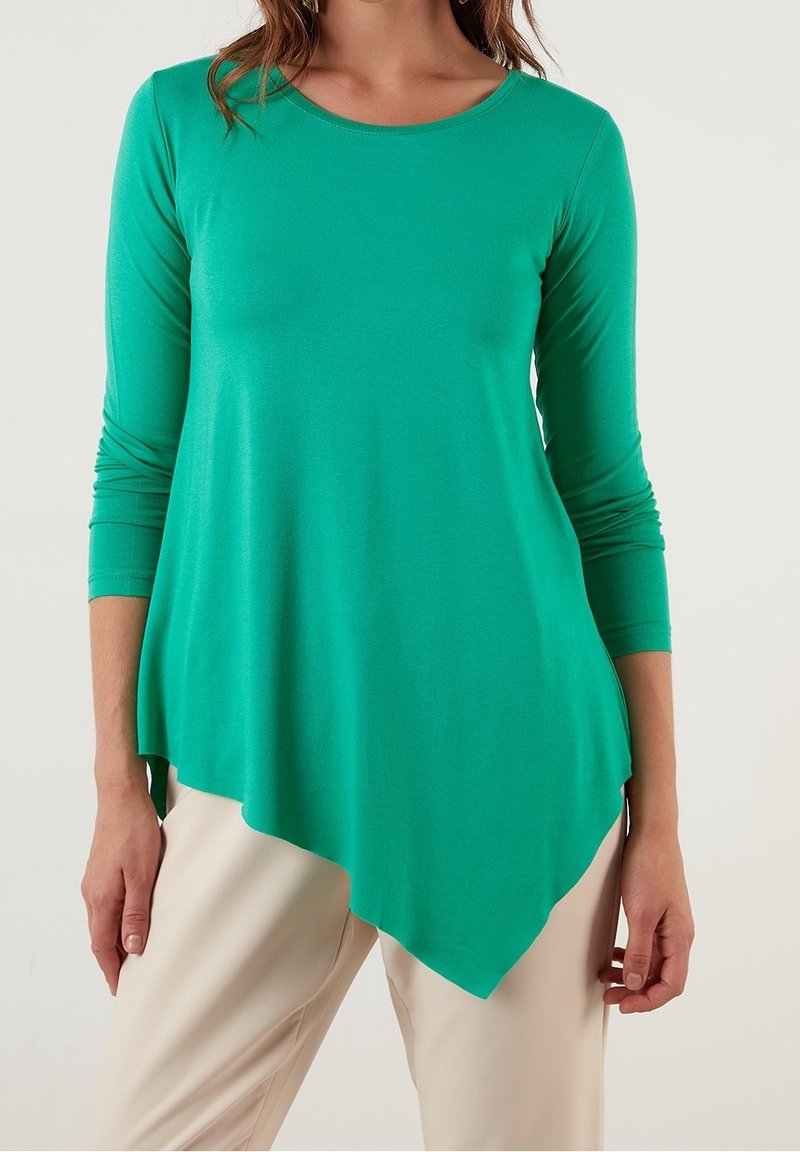 Grön långärmad tröja med rundad halsringning och asymmetrisk fåll. Tillverkad av mjukt material med en slät textur för komfort.