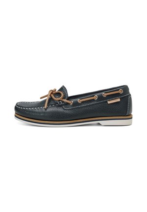 Chaussure bateau en cuir noir avec coutures blanches, lacets en cuir fauve noués en nœud papillon et semelle blanche avec rayures fauve et bleu marine.