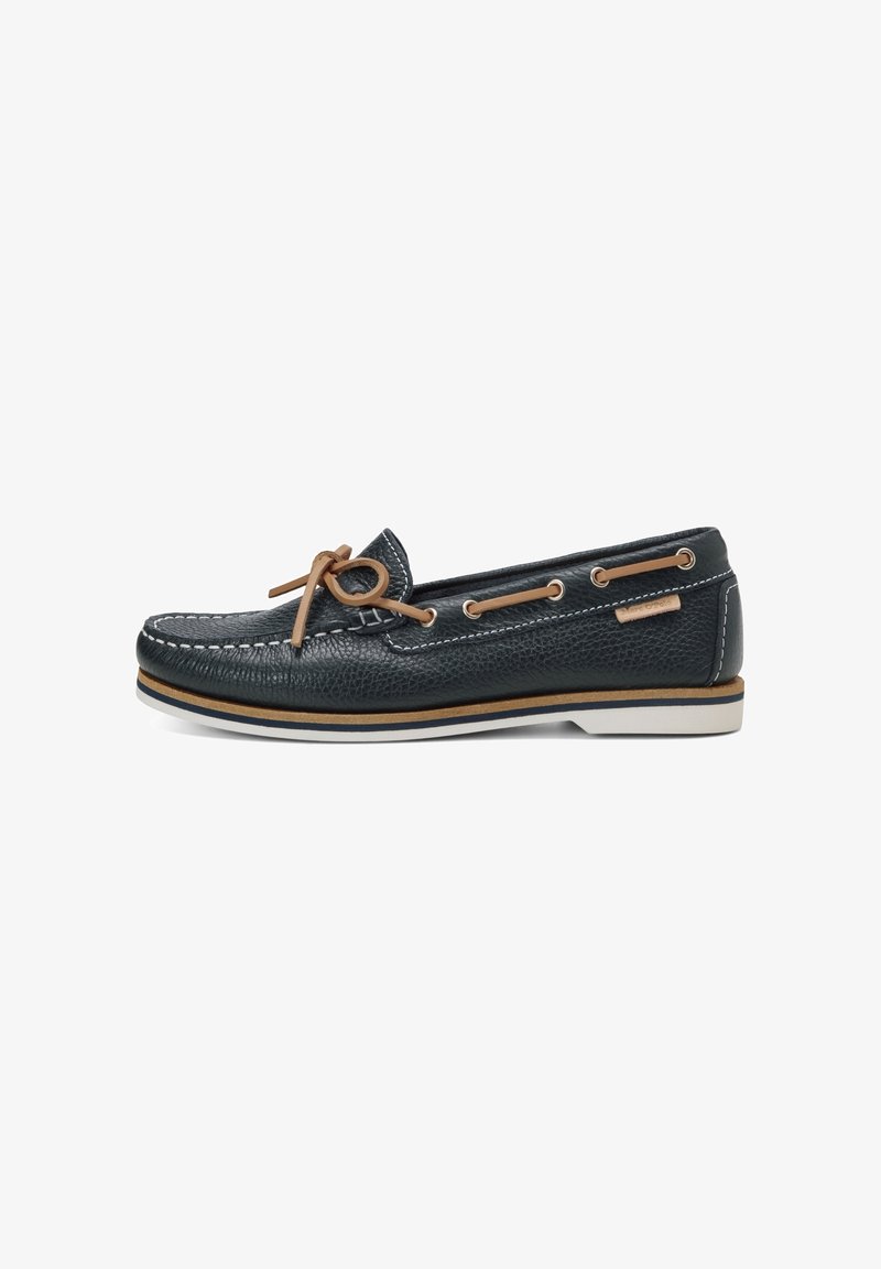 Chaussure bateau en cuir noir avec coutures blanches, lacets en cuir fauve noués en nœud papillon et semelle blanche avec rayures fauve et bleu marine.