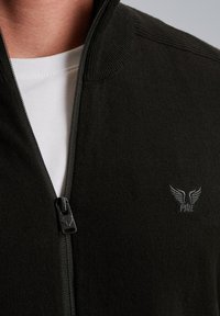 Tmavo zelený zipsový sveter s rebrovaným golierom, s bielou vnútornou vrstvou a vyšívaným logom na hrudi. Hladká textúra, priliehavý strih.