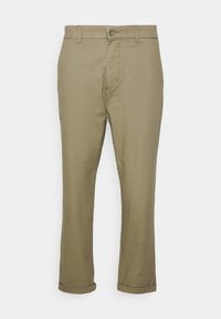 Spodnie khaki o prostym kroju, wykonane z mieszanki bawełny, z przednimi kieszeniami i podwiniętymi mankietami. Zapięcie na guzik w pasie.