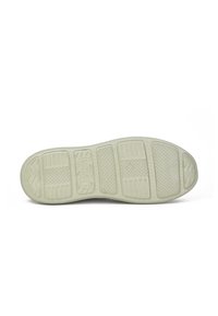 Suela de zapatilla de goma en color blanco roto con patrones texturizados, incluyendo surcos y agarres para tracción, y un borde liso y redondeado.