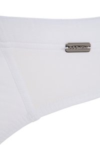 Slip di cotone bianco con design triangolare, trama liscia e un'etichetta in metallo del marchio Jockey sulla cintura.