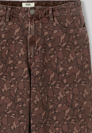 Jean denim marron à motifs avec des formes abstraites marron clair. Comprend une conception standard à cinq poches et une fermeture par bouton en métal.