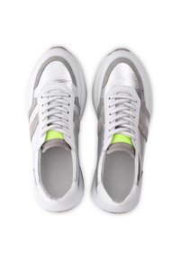 Ein Paar weiße Sneaker mit metallisch silbernen und grauen Akzenten, weißen Schnürsenkeln und neon grünen Details auf der Zunge, von oben gezeigt.