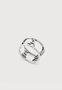 Δύο ασημένια μεταλλικά δαχτυλίδια με γράμματα κομμένα που σχηματίζουν τα "AF" πλεγμένα μεταξύ τους σε απλό λευκό φόντο.