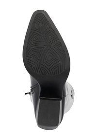 Bota de cuero negro con una suela de goma texturizada que presenta patrones geométricos, punta redondeada y una altura de tacón modesta.