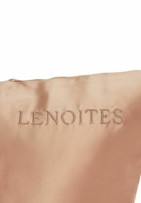 Satin-kudde i ljusrosa med prägling av texten "LENOITES". Har en slät yta och en strukturerad form som betonar den minimalistska designen.