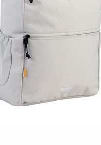 Grijze rugzak van textuurstof, met een ritscompartiment, zwarte trekstangen en een subtiel logo onderaan. Accenten in oranje.