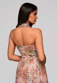 Sukienka w kwiatowy nadruk w pastelowych kolorach, z dopasowanym gorsetem, zamkiem błyskawicznym z tyłu i dekoltem na halter. Lekka tkanina o subtelnej fakturze.