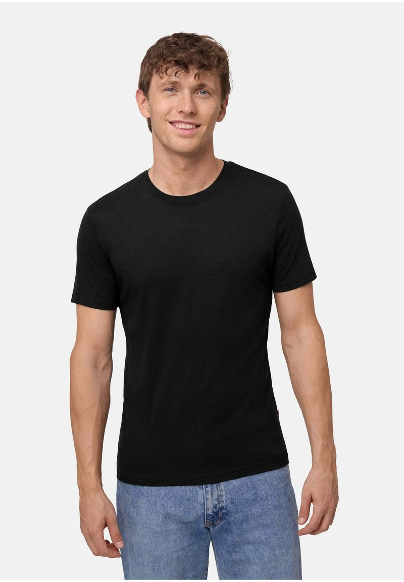 Schwarzes Baumwoll-T-Shirt mit rundem Halsausschnitt, kurzen Ärmeln und regulärer Passform. Glatte Textur und minimales Design, kombiniert mit hellblauen Jeans.
