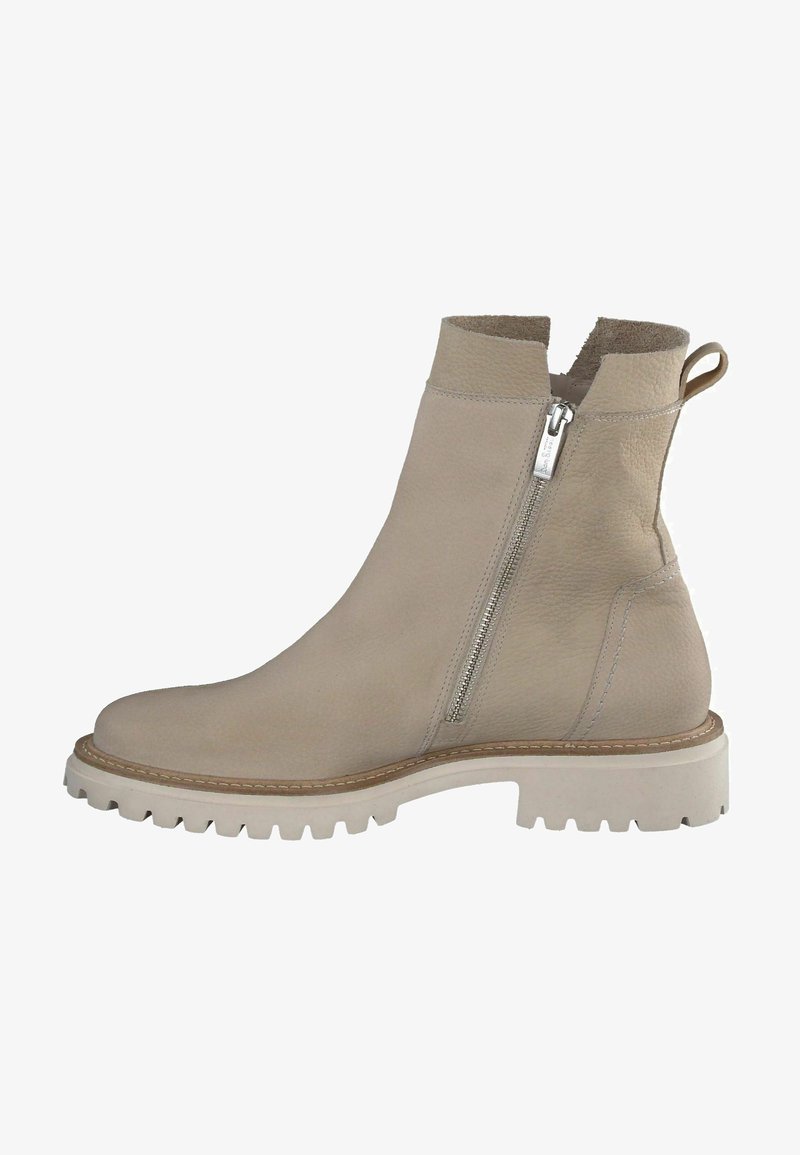 Bottines beige à fermeture éclair sur le côté. Fabriquées en cuir texturé, avec une épaisse semelle blanche à rainures profondes et une languette à l'arrière.