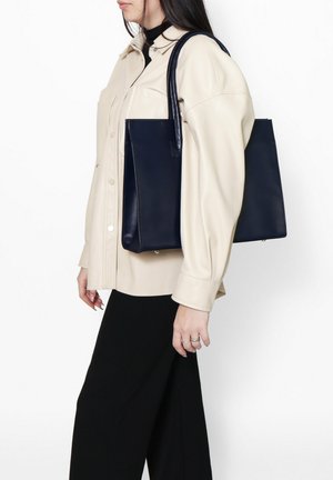 Marine leren tote bag met een gestructureerd design, featuring lange handvaten en zonder zichtbare patronen of hardwaredetails.