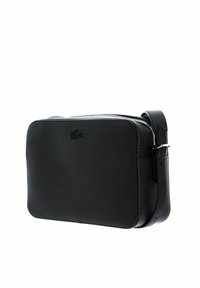 Borsa a tracolla nera in materiale sintetico con superficie texturizzata, forma rettangolare, chiusura con zip e tracolla regolabile. Logo Lacoste impresso sul davanti.