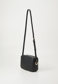 Schwarze Kunstleder-Crossbody-Tasche mit rechteckiger Form, goldenen Hardware-Akzenten und verstellbarem Schulterriemen. Glatte Textur mit gesteppten Kanten.
