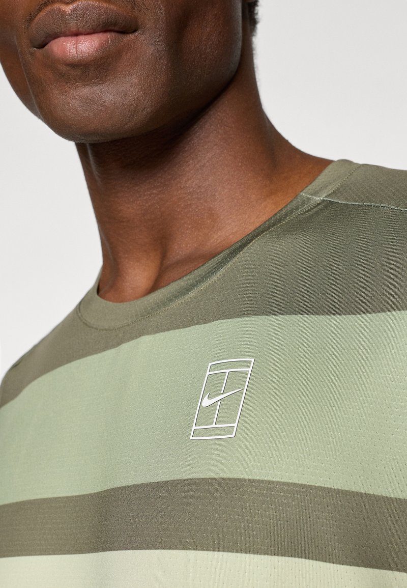 Nike short-sleeve shirt featuring horizontal olive and green stripes, round neckline, and a white Nike logo on the chest.