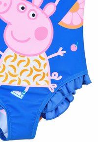 Blauer Badeanzug mit einer rosa Cartoonfigur und einem Muster aus gelben Bananen, einer gestuften Rüsche am Saum und verspielten Akzenten wie Kirschen.