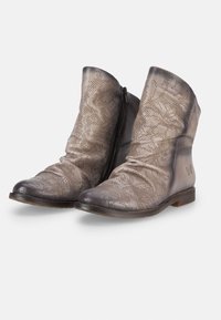 Botas de tobillo de cuero en un color gris degradado. Diseño perforado con detalles arrugados y cremallera lateral. Punta redondeada y suela plana.