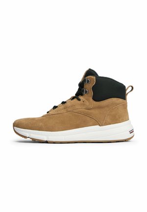 Bruine suède hoge sneaker met zwarte gewatteerde kraag, zwarte veters, witte zool en een trekhaak bij de hiel, zijaanzicht.