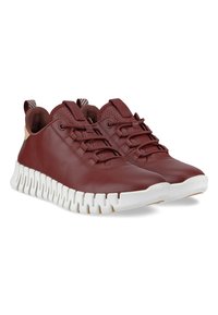 Burgundowe skórzane sneakersy z białymi, rzeźbionymi gumowymi podeszwami, z okrągłymi sznurówkami i tylnymi uchwytami ułatwiającymi zakładanie. Teksturowane detale w górnej części.