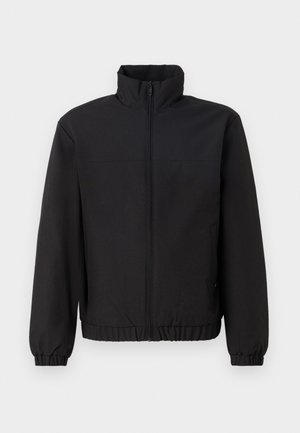 Zwarte jas met hoge kraag, een ritssluiting aan de voorkant, elastische manchetten en een elastische tailleband. Gladde textuur, eenvoudig ontwerp zonder patronen of accenten.