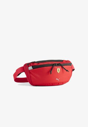 Rødt bælte-/hofte- taske lavet af tekstureret stof med en sort lynlås og netpanel på siden. Har Ferrari-logo og Puma-mærkning foran.