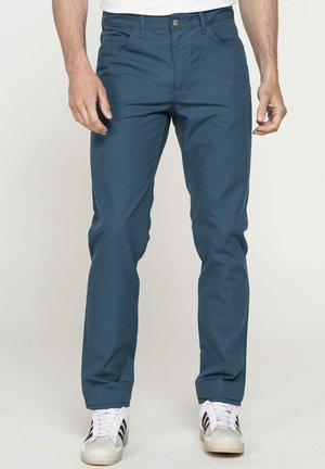 Pantaloni in cotone blu con vestibilità slim, dotati di chiusura con bottone e cerniera, tasche frontali e dettagli di cucitura a contrasto.